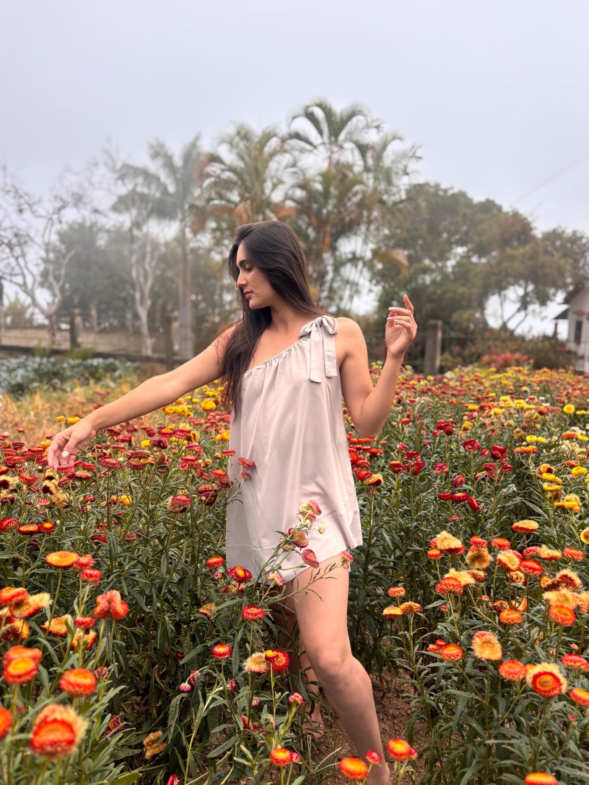 Francis Virginia Borges caminando en campo floral abierto